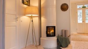 a corner of a room with a fireplace and a lamp at Villa Maija 4 Upperside in Hanko