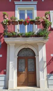 un bâtiment avec une porte recouverte de plantes en pot dans l'établissement LA POLVERISTA Appartamento riservato e comodo, 