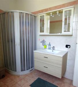 La salle de bains est pourvue d'un lavabo et d'une grande douche. dans l'établissement LA POLVERISTA Appartamento riservato e comodo, 