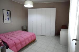 - une chambre avec un lit rose et une armoire dans l'établissement LA POLVERISTA Appartamento riservato e comodo, 