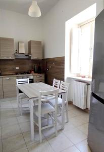 - une table et des chaises blanches dans la cuisine dans l'établissement LA POLVERISTA Appartamento riservato e comodo, 