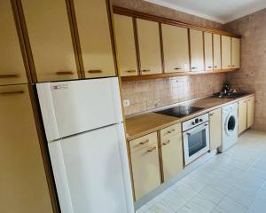 a kitchen with a white refrigerator and a dishwasher at Apartamento Almazara in Valencia de Alcántara