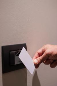 a person holding a white piece of paper in a lightswitch at Augusto132 in Naples