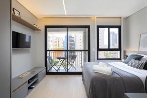a bedroom with a bed and a balcony at Nex One Ministro Ferreira Alves in Sao Paulo