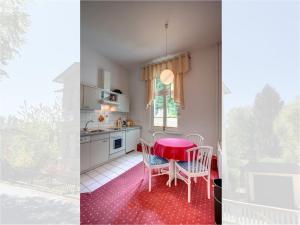 a kitchen with a table and chairs and a red floor at Heringsdorf, Villa Lindemann W3 in Heringsdorf