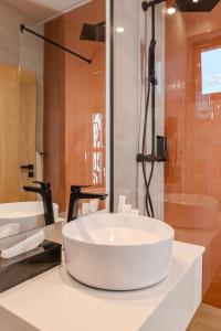 a white bathroom with two sinks and a shower at Hotel Branco Timisoara in Timişoara
