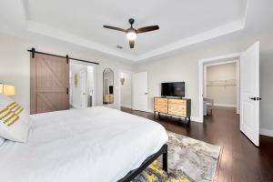 ein weißes Schlafzimmer mit einem Bett und einem Deckenventilator in der Unterkunft Family Friendly New Luxury Home Centrally located in Atlanta