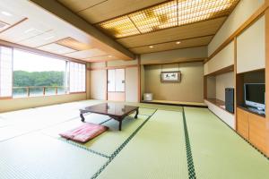 a living room with a table and a tv at Hotel Crystal Palace in Hitachinaka