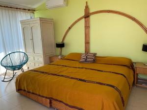 1 dormitorio con 1 cama grande y 1 silla en Casa Azul en la orilla del Lago Tequesquitengo en Tequesquitengo