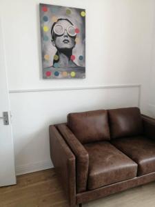 a brown couch in a living room with a painting at Perfect apartment - close to the train station in Cork