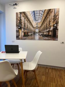 une chambre avec une table et un ordinateur portable sur un mur dans l'établissement MiAp ORTI 31, à Milan