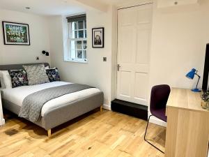 een slaapkamer met een bed, een bureau en een raam bij Palmer Apartment, 3 guests, Free Wifi, Great Transport Links, close to Uni, Hospital & Town Centre in Reading