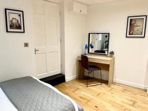 - une chambre avec un lit et un bureau avec un miroir dans l'établissement Palmer Apartment, 3 guests, Free Wifi, Great Transport Links, close to Uni, Hospital & Town Centre, à Reading