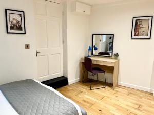 a bedroom with a bed and a desk with a mirror at Palmer Apartment, 3 guests, Free Wifi, Great Transport Links, close to Uni, Hospital & Town Centre in Reading