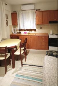 een keuken met een tafel en stoelen en een fornuis bij Evaggelia's Apartments 3 Διαμονή στο χωριό 