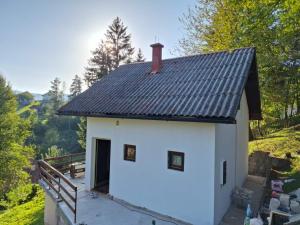 a small white building with a metal roof at Vikendica Savic TKM in Pale