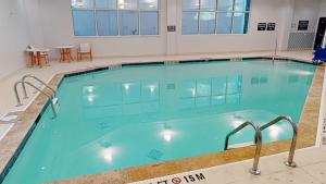 a large indoor swimming pool with blue water at Hotel Spice & Sky Atlanta Perimeter in Atlanta