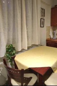 um quarto com uma mesa, uma cadeira e uma janela em Evaggelia's Apartments 3 Διαμονή στο χωριό 