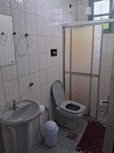 a bathroom with a toilet and a sink and a shower at Apartamento em Jacaraipe ES 3 quartos in Jacaraípe +18 photos