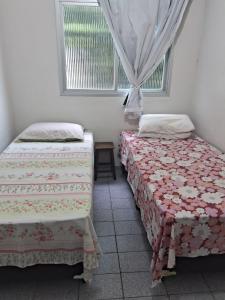 dos camas sentadas una al lado de la otra en una habitación en Apartamento em Jacaraipe ES 3 quartos, en Jacaraípe