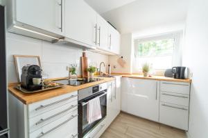 a kitchen with white cabinets and a wooden counter top at Charmante Stadtwohnung in Essen