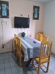 Apartamento em Jacaraipe ES 3 quartos في جاكارابي: طاولة طعام مع كراسي وتلفزيون