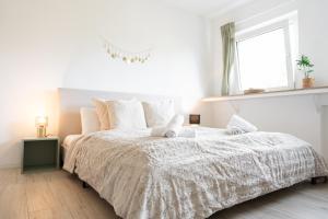 een witte slaapkamer met een groot bed en een raam bij Charmante Stadtwohnung in Essen