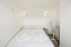 WoolwichにあるStunning 2-Bd Flat in Woolwichのベッドルーム1室(白いシーツとタオル付きのベッド1台付)