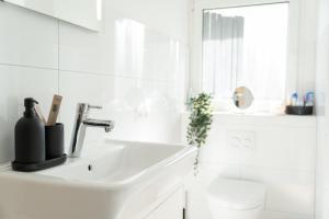 een witte badkamer met een wastafel en een douche bij Charmante Stadtwohnung in Essen +8 foto's