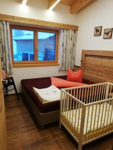 ein Wohnzimmer mit einem Sofa und einem Kinderbett in der Unterkunft Haus Bergjuwel in Huben