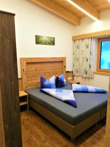 a bedroom with a bed with blue and white pillows at Haus Bergjuwel in Huben