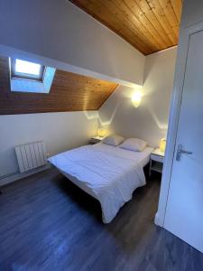 a bedroom with two beds and a wooden ceiling at Chalet Saint-Patrick - Le Convivial in Vars +2 photos