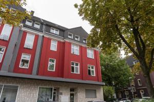 een rood gebouw aan de straatkant bij Charmante Stadtwohnung in Essen