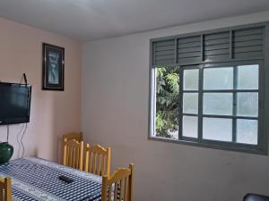 Apartamento em Jacaraipe ES 3 quartos في جاكارابي: غرفة طعام مع طاولة ونافذة