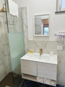 Baño blanco con lavabo y espejo en B&B Il Paradiso di Capri, en Anacapri