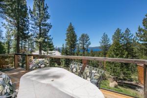 un tavolo su una terrazza con vista sugli alberi di Beaver Lake View by Tahoe Getaways - Pet Friendly 3 BR with Hot Tub, Wood Fireplace & Close to Skiing a Kings Beach
