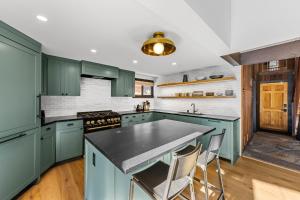 a kitchen with green cabinets and a large island at Birchwood Retreat by Tahoe Getaways - Newly Remodeled Pet Friendly Home in Alpine Meadows with Wood Fireplace, Hot Tub & Ski Shuttle! in Alpine Meadows