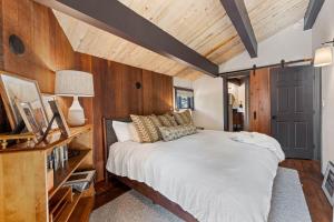 a bedroom with a large bed and wooden walls at Birchwood Retreat by Tahoe Getaways - Newly Remodeled Pet Friendly Home in Alpine Meadows with Wood Fireplace, Hot Tub & Ski Shuttle! in Alpine Meadows