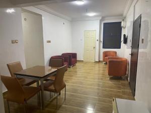 a waiting room with a table and chairs at Ibiyemi Apartment in Abuja