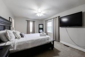 a bedroom with a bed and a flat screen tv at Rockin' West Nashville Retreat - 5 miles from downtown in Nashville