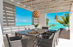 a patio with a table and chairs and the ocean at Ocean Dream 5 BR Villa Aqua in Long Bay Hills