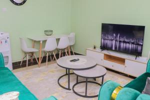 een woonkamer met een bank, een tv en een tafel bij City's Apartment 1 and 2 bedroom in Kisumu