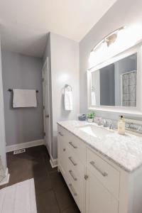 a white bathroom with a sink and a mirror at Rockin' West Nashville Retreat - 5 miles from downtown in Nashville
