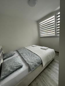 a bed in a white room with a window at Apartman “ Ismar “ in Travnik