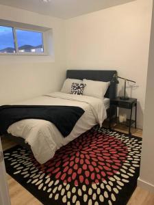 Schlafzimmer mit einem Bett mit einem roten und weißen Teppich in der Unterkunft Cheerful and cozy 1 bedroom,separate entrance in Winnipeg