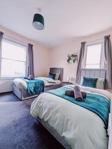 a bedroom with two beds and two windows at Spacious 10 Bed Contractor Pad in Bray
