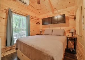 a bedroom with a bed in a wooden cabin at Thomas Cabin Forest Tiny Cabin With Hot Tub in Chattanooga