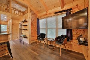 Μια τηλεόραση ή/και κέντρο ψυχαγωγίας στο Thomas Cabin Forest Tiny Cabin With Hot Tub