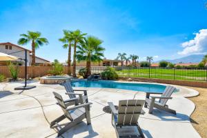 a patio with two chairs and a swimming pool at Palms Place in Indio in Indio