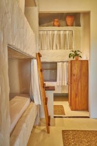 a room with two bunk beds with a ladder at Evoé Caraíva in Caraíva